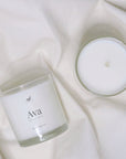 Scented coconut wax candle in glass vessel.
