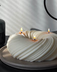 A stylized photo of Serene, 3-wick sculptural candle.
