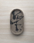 Concrete trinket tray in wenge with abstract off-black color accents.