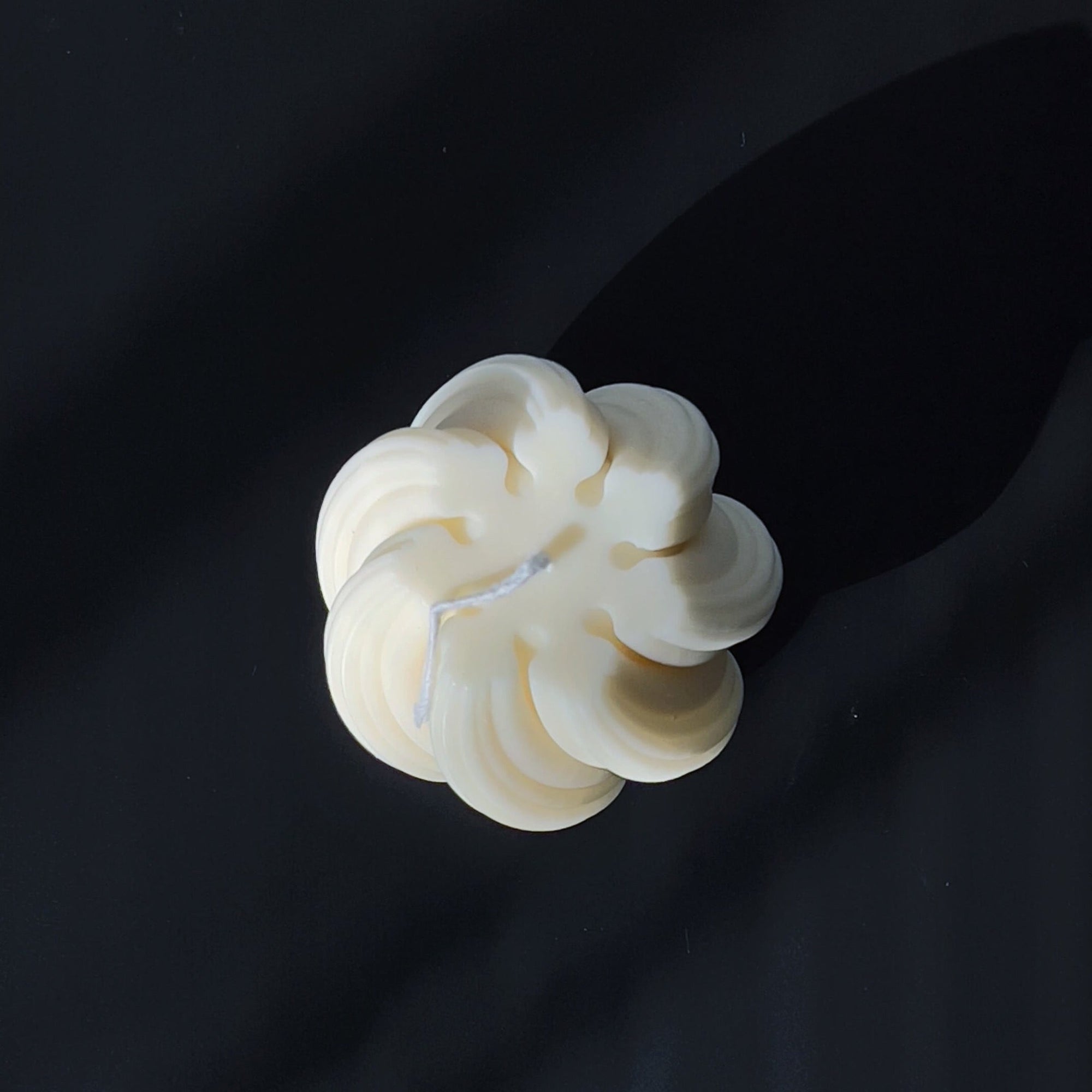 Overhead view of Nev sculptural candle with intricate ribbed swirl pattern.
