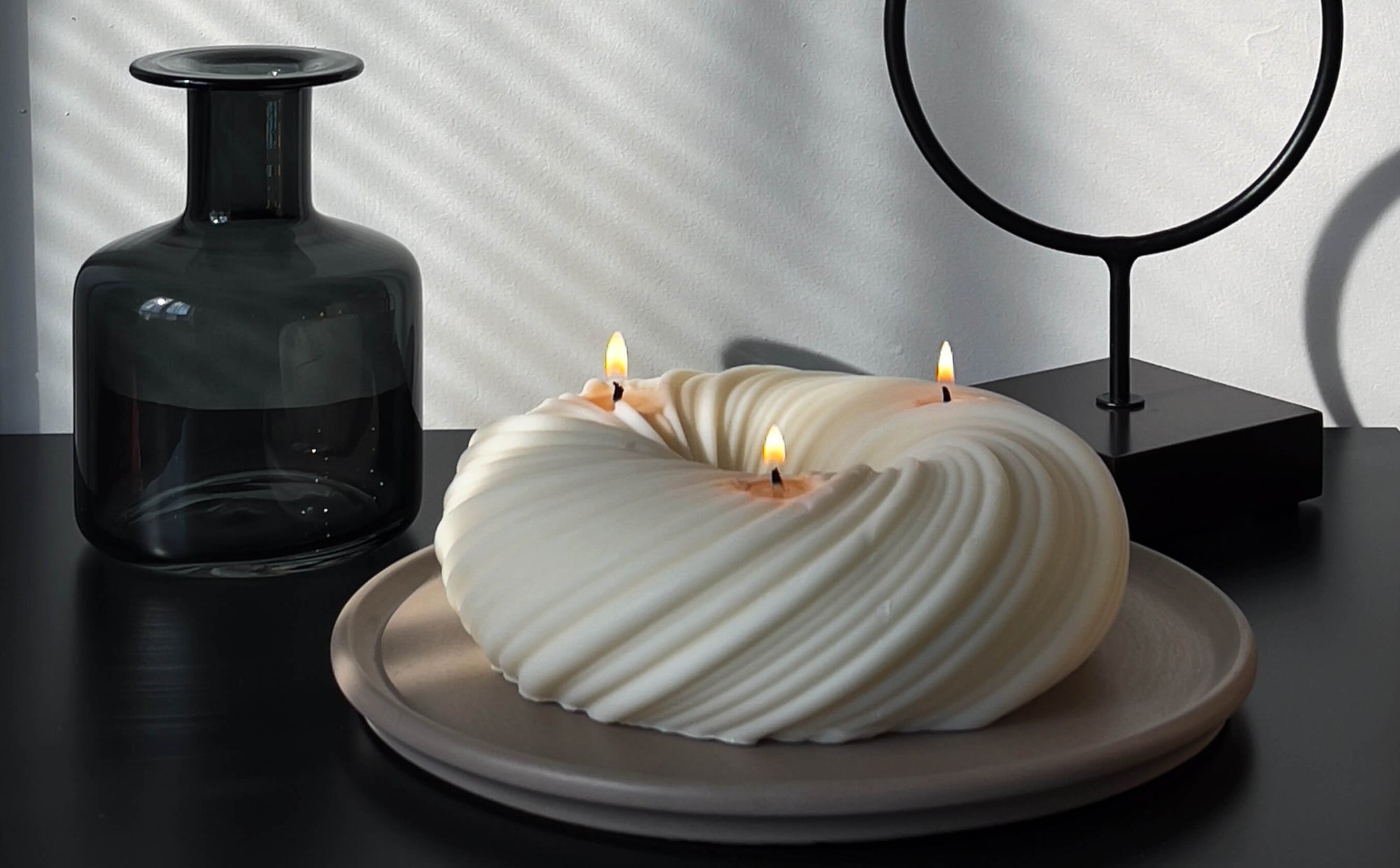 A stylized photo of Serene, 3-wick sculptural candle. 