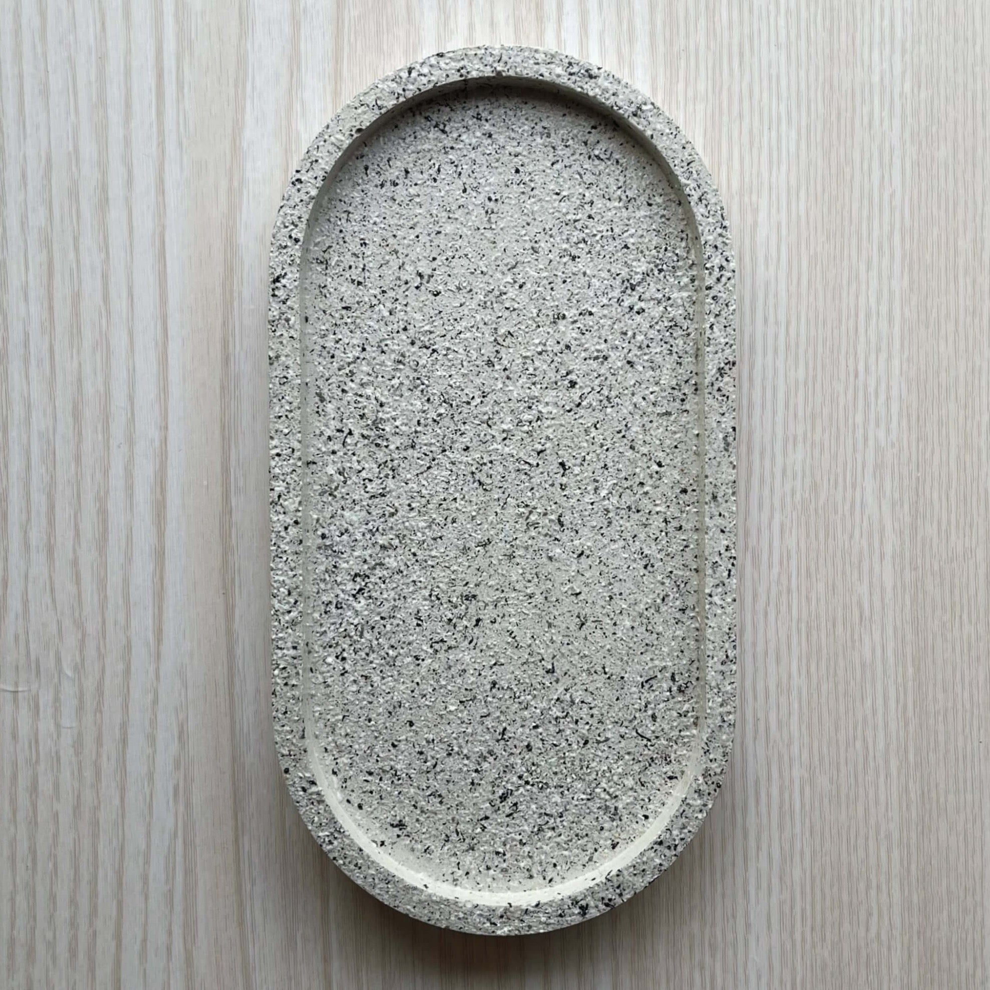 Concrete trinket tray in neutral tone with natural stone texture.