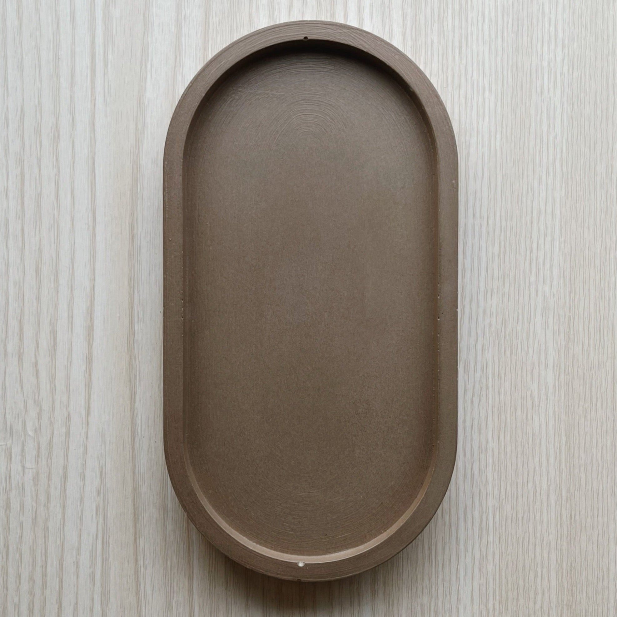 Oval (pill shaped) concrete trinket tray in natural wenge.